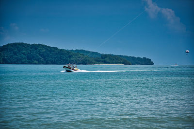 Parasailing on the waves of the azure andaman sea under the blue sky near the shores of cenang beach