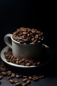 Close-up of coffee beans on table against black background
