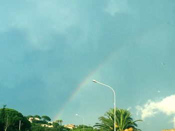 Low angle view of rainbow over trees