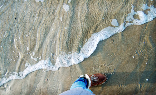 Low section of people standing on beach