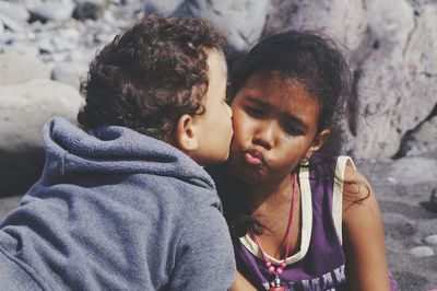 Close-up of brother kissing sister outdoors