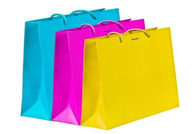 Close-up of colorful paper bags over white background