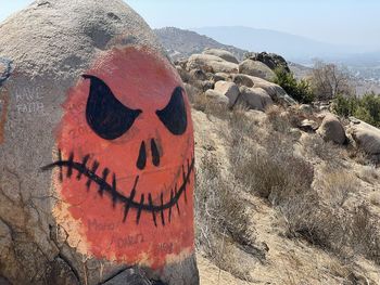 High angle view of text and face on rock