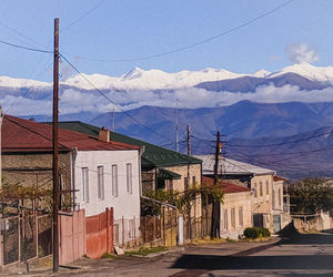 Houses by road against sky in city
