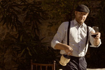 Midsection of man holding ice cream standing outdoors