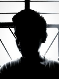 Rear view of man looking through window