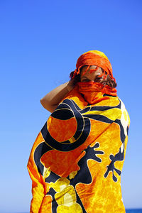 Low angle view of person against clear blue sky