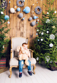 Portrait of girl with toys on tree at home