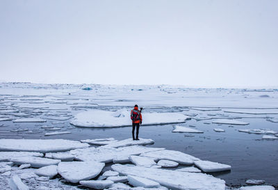 Full length of man standing on snow against sky