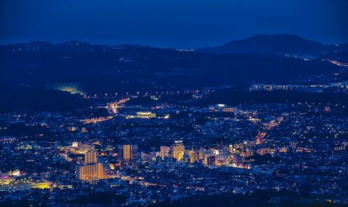 Aerial view of illuminated cityscape against sky at dusk