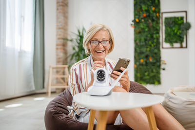 Young woman using mobile phone while sitting at home