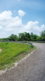 Road amidst field against sky