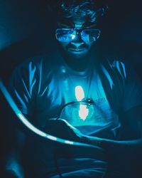 Portrait of young man with light painting in darkroom