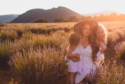 Beautiful woman standing on field with purple flowers