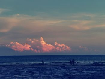 Silhouette people on beach against sky during sunset