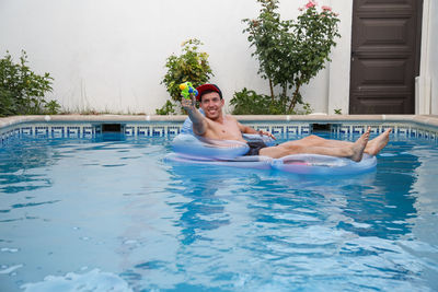 Portrait of smiling young man in swimming pool