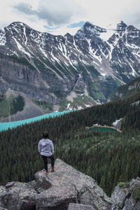 Scenic view of snowcapped mountains with person standing in the foreground