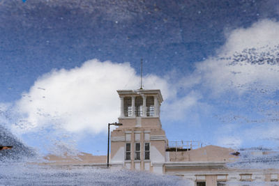 Lighthouse by sea against sky