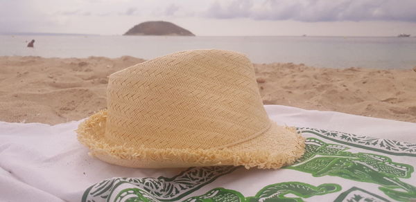 Close-up of hat on sand at beach