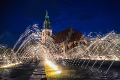 Illuminated building against sky at night