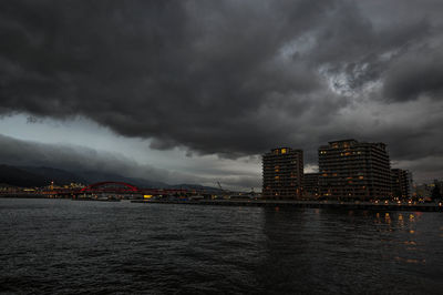 City by sea against storm clouds