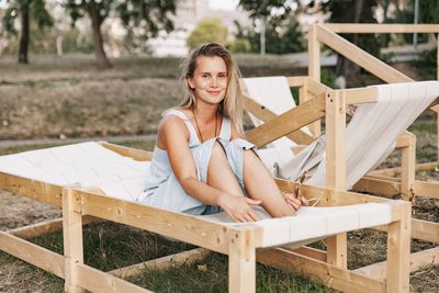 Portrait of young woman sitting on table