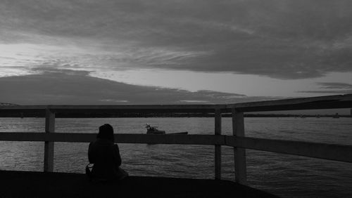 Pier on sea against cloudy sky