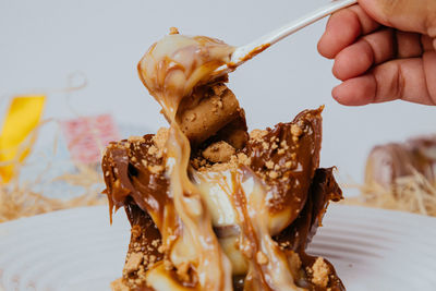 Close-up of hand holding ice cream in plate