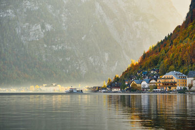 Scenic view of lake by buildings against mountain