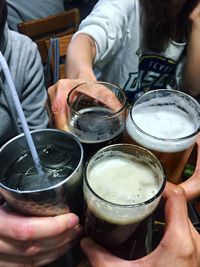 Midsection of man holding beer glass