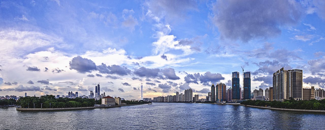 building exterior, architecture, city, skyscraper, water, waterfront, built structure, cityscape, sky, modern, river, urban skyline, tall - high, office building, cloud - sky, financial district, tower, sea, cloud, skyline