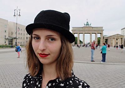 Portrait of woman standing against building in city