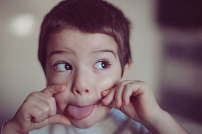 Close-up of boy sticking out tongue