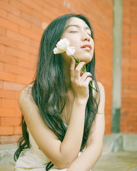 Portrait of beautiful woman with red flower