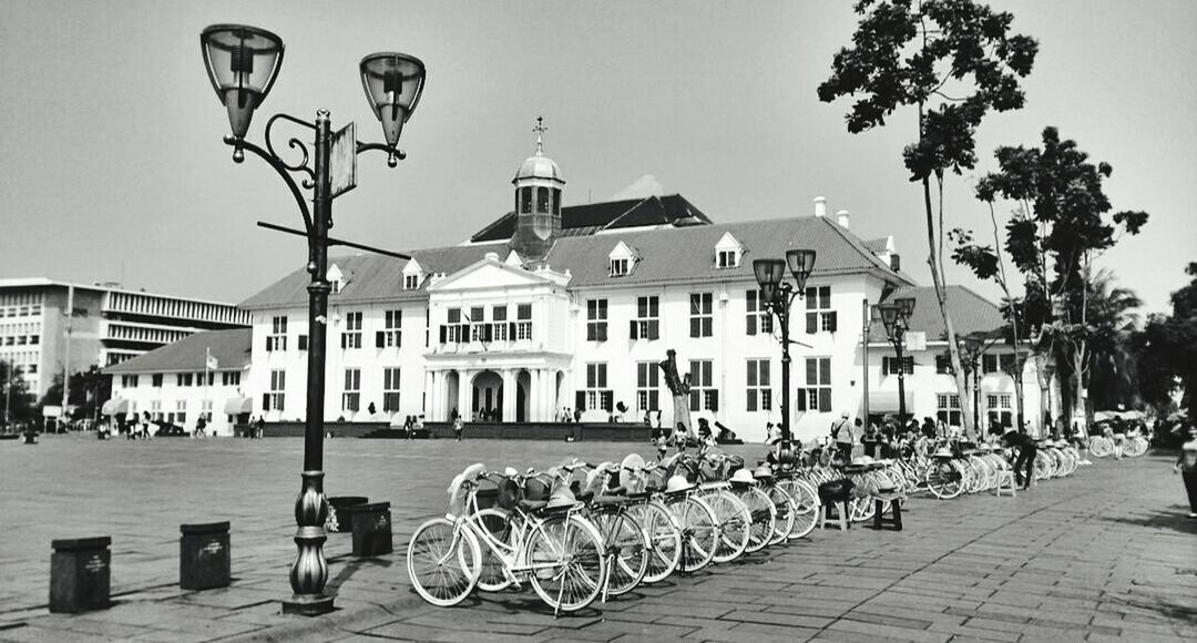 BICYCLES PARKED ON ROADSIDE IN FRONT OF BUILDINGS