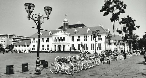 Bicycles parked on street in front of buildings against clear sky