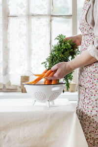 Midsection of woman holding food at home