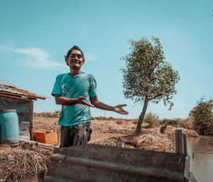 Portrait of young man standing against sky