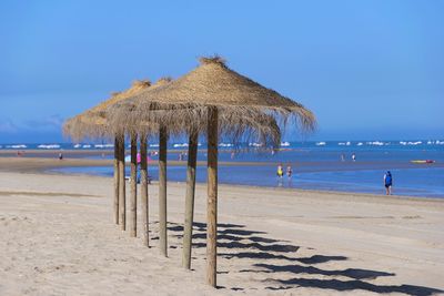 Lifeguard hut on beach against blue sky