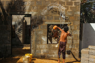 Side view of woman standing against wall