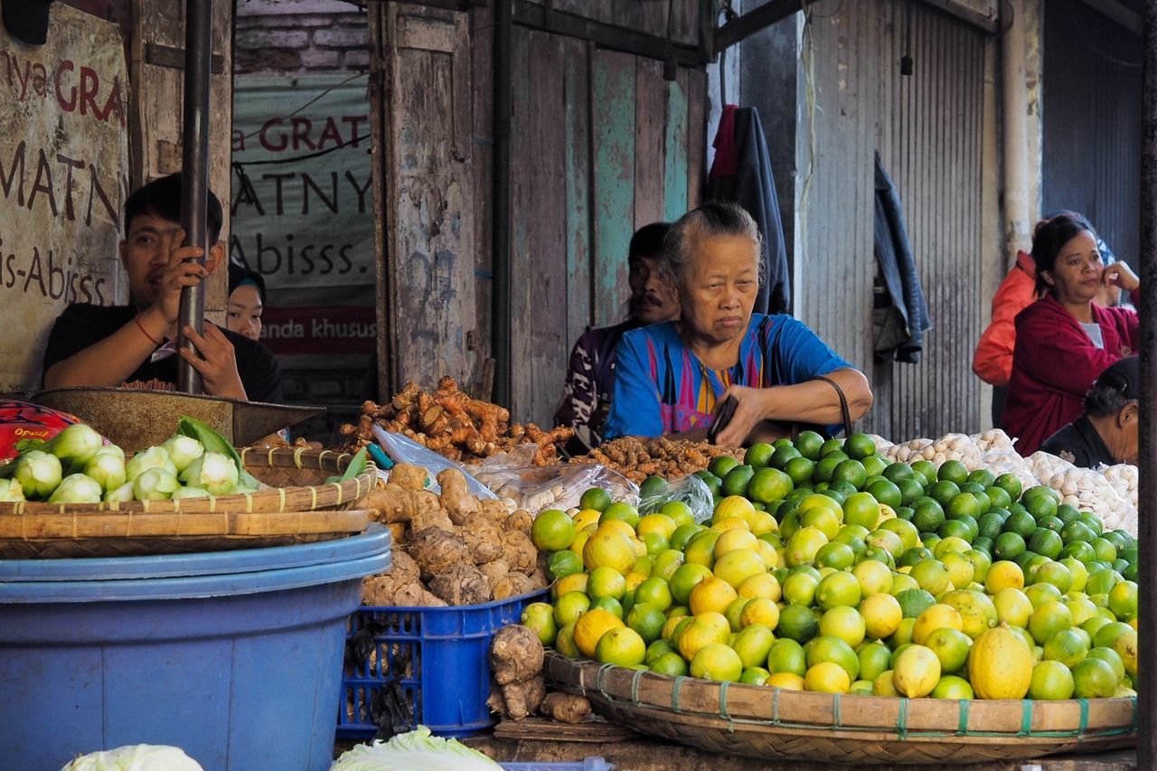 food, food and drink, fruit, healthy eating, adult, market, retail, wellbeing, selling, business, men, small business, market stall, women, market vendor, real people, people, abundance, for sale, vendor, outdoors, street market