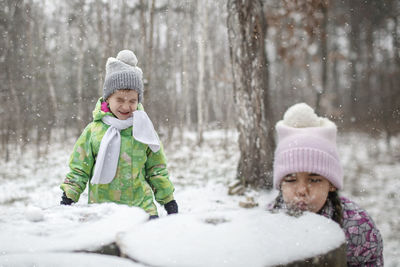 Cute kids playing on snow during winter