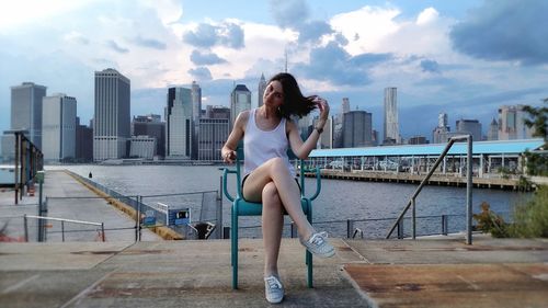 Woman with arms outstretched against cityscape