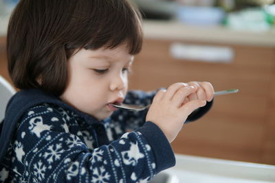 Close-up of cute baby girl eating from spoon