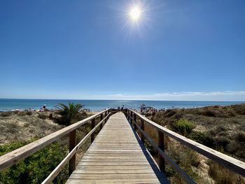 Footbridge over sea against sky