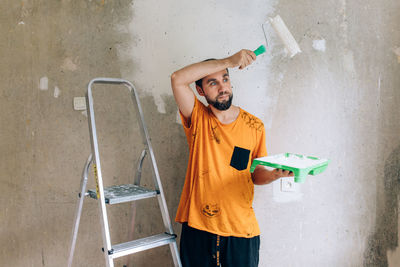 Man painting wall at home