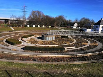 High angle view of park by building against blue sky