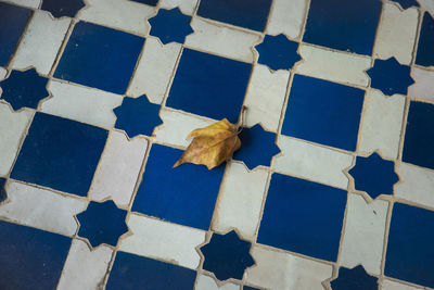 High angle view of dry leaf on tiled floor