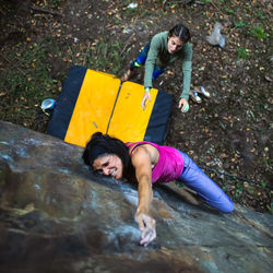 High angle view of woman climbing on boulder