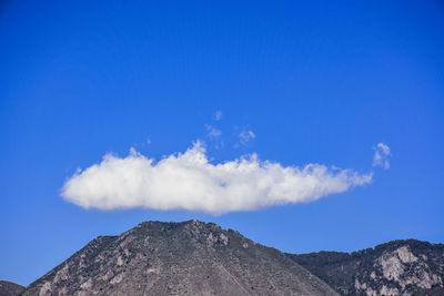 Low angle view of mountain against blue sky